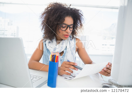 Pretty photo editor working at her desk Pretty photo editor working at her desk 12178472
