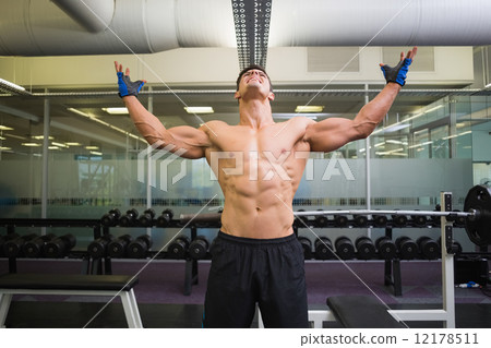 Bodybuilder with arms raised in gym 12178511