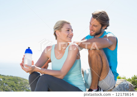 Fit couple taking a break at summit smiling at each other 12178614