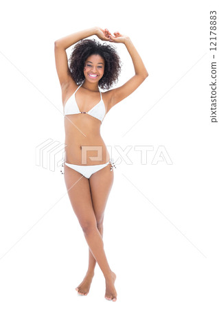 Fit girl in white bikini smiling at camera 12178883