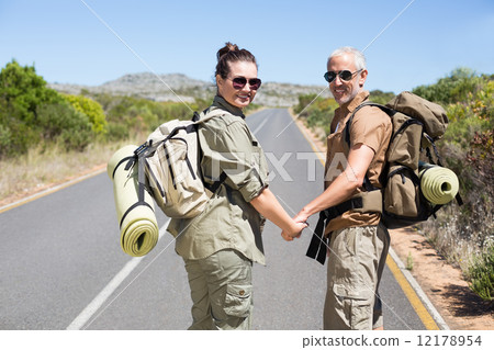 Hitch hiking couple standing holding hands on the road 12178954