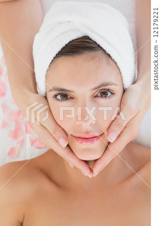 Attractive young woman receiving facial massage at spa center Attractive young woman receiving facial massage at spa center 12179221