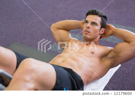 Muscular man doing abdominal crunches in gym Muscular man doing abdominal crunches in gym 12179600