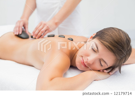 Beautiful woman receiving stone massage at spa center 12179714