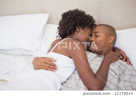 Happy couple in bed together Happy couple in bed together 12179814