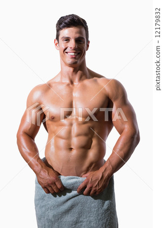 Smiling shirtless muscular man wrapped in white towel 12179832