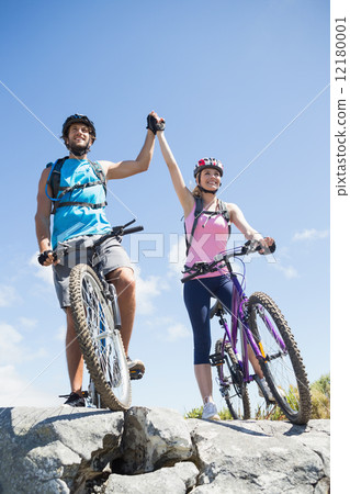 Fit cyclist couple happy to have reached the summit Fit cyclist couple happy to have reached the summit 12180001