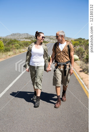 Hitch hiking couple holding hands on the road 12180132