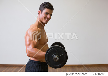 Shirtless muscular man lifting barbell in gym Shirtless muscular man lifting barbell in gym 12180283