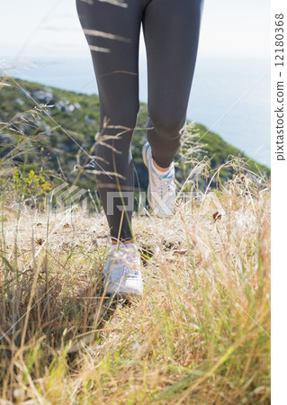 Fit woman jogging on mountain trail Fit woman jogging on mountain trail 12180368