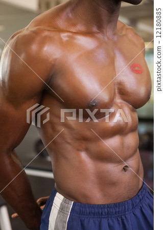 Shirtless muscular man with lipstick mark on chest 12180885