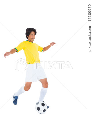 Football player in yellow kicking ball 12180970