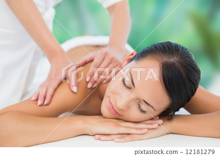 Beautiful brunette enjoying a back massage 12181279