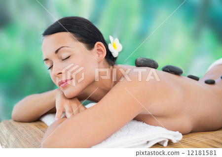 Beautiful brunette enjoying a hot stone massage 12181581