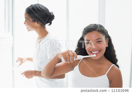 Pretty mother brushing her teeth with her daughter 12181696