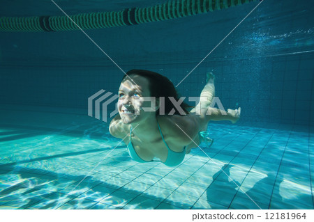 Pretty brunette smiling and swimming underwater Pretty brunette smiling and swimming underwater 12181964