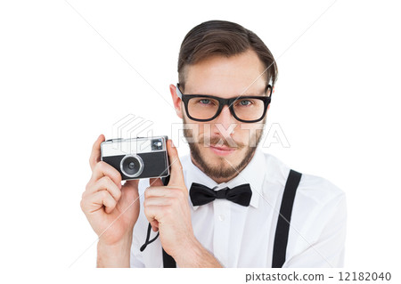 Geeky hipster holding a retro camera Geeky hipster holding a retro camera 12182040