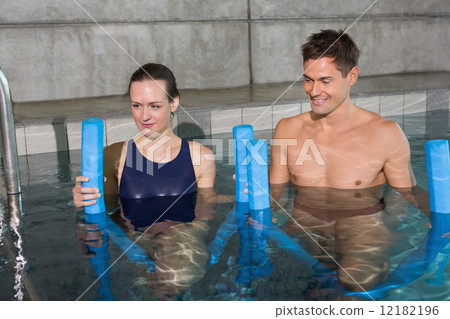 Happy couple holding foam rollers 12182196