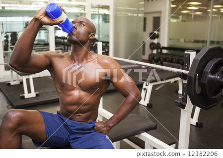 Muscular man drinking energy drink in gym Muscular man drinking energy drink in gym 12182206