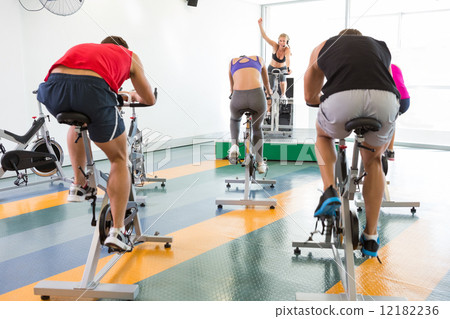 Spin class working out with motivational instructor 12182236