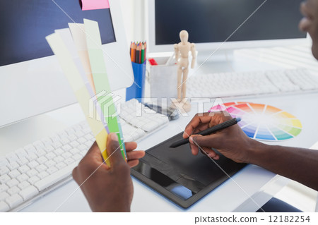 Designer sitting at his desk working with digitizer 12182254