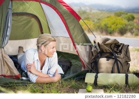 Attractive happy blonde lying in tent 12182280
