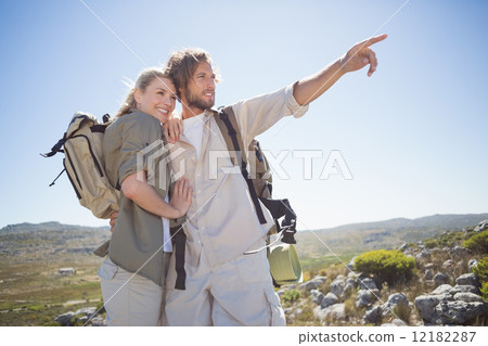 Hiking couple standing on mountain terrain looking around 12182287