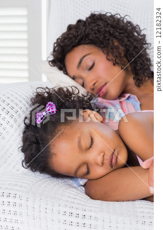 Cute daughter sleeping with mother on the sofa Cute daughter sleeping with mother on the sofa 12182324