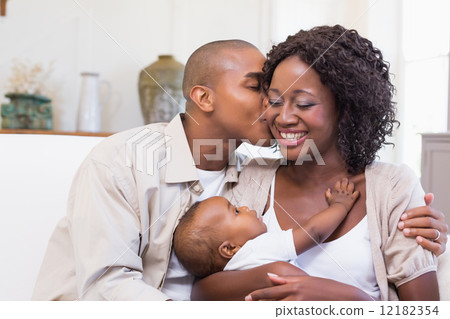 Happy parents spending time with baby on the couch 12182354