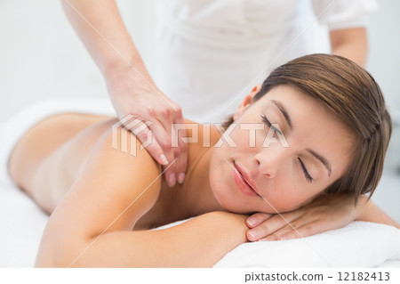 Attractive woman receiving shoulder massage at spa center 12182413