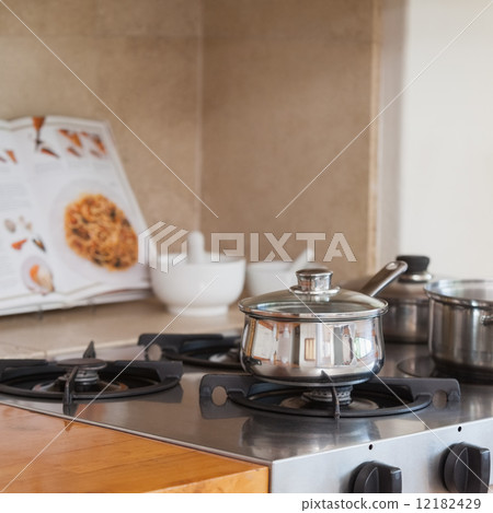 Stove top with saucepan and recipe book 12182429