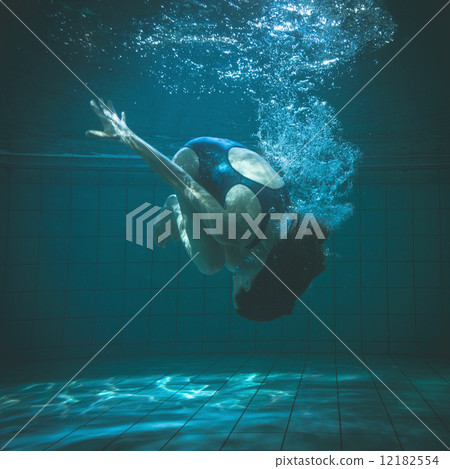 Athletic swimmer doing a somersault underwater 12182554