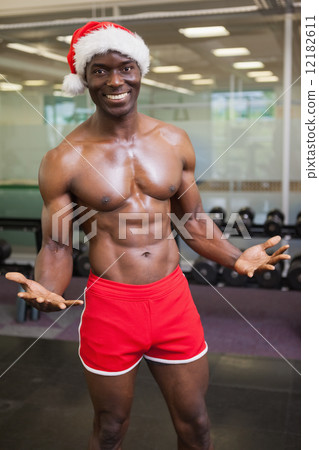 Shirtless macho man in santa hat at the gym Shirtless macho man in santa hat at the gym 12182611