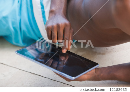 Shirtless man using his tablet pc Shirtless man using his tablet pc 12182685