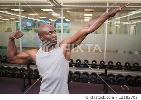 Muscular man posing in gym Muscular man posing in gym 12182702
