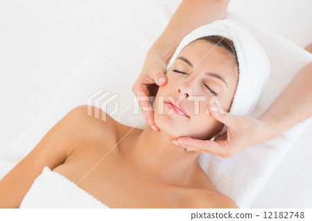 Attractive woman receiving facial massage at spa center Attractive woman receiving facial massage at spa center 12182748