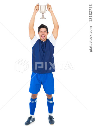 Football player in blue holding winners cup 12182758