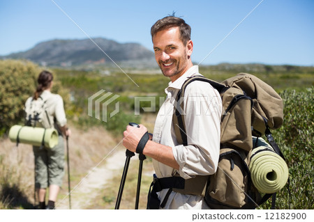 Happy hiking couple walking on country trail 12182900