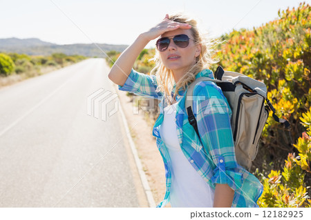 Attractive blonde hitch hiking on rural road 12182925