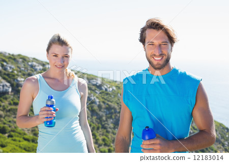 Fit couple standing at summit smiling at camera 12183014