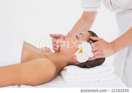 Attractive young woman receiving head massage at spa center Attractive young woman receiving head massage at spa center 12183293