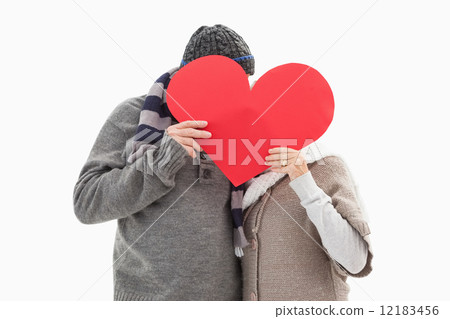 Happy mature couple in winter clothes holding red heart 12183456
