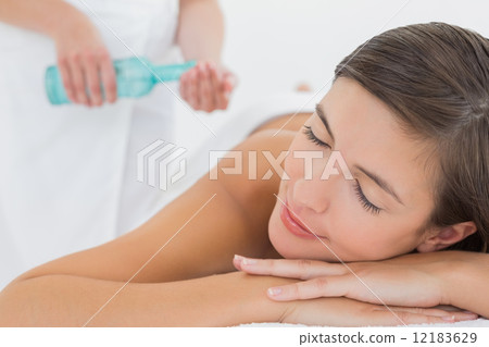 Attractive woman getting massage oil on her back 12183629