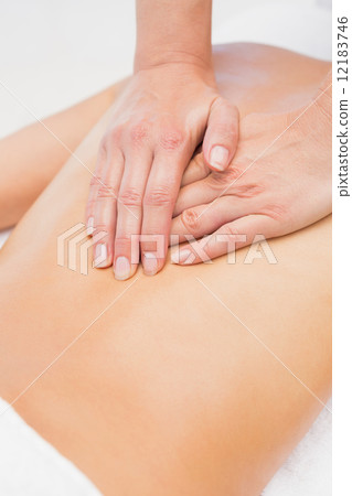 Attractive young woman receiving back massage at spa center 12183746
