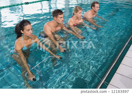 Fitness class doing aqua aerobics on exercise bikes