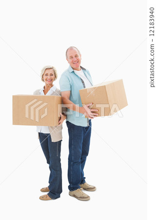 Older couple smiling at camera holding moving boxes Older couple smiling at camera holding moving boxes 12183940