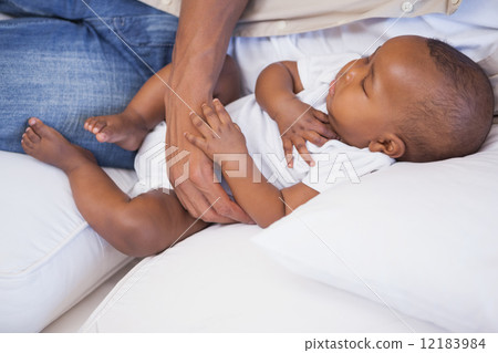 Happy father napping with baby son on couch 12183984