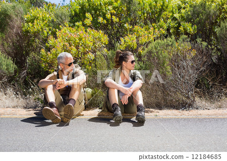 Hitch hiking couple sitting on the side of the road Hitch hiking couple sitting on the side of the road 12184685