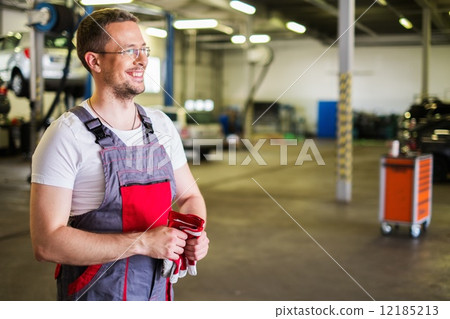 Serviceman in a car workshop Serviceman in a car workshop 12185213