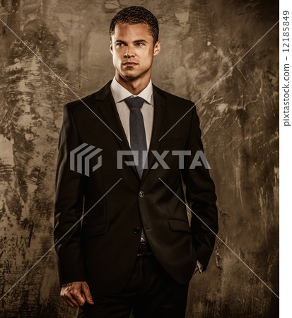 Well-dressed man in black suit against grunge wall Well-dressed man in black suit against grunge wall 12185849